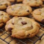 A display of freshly baked chocolate chip cookie variations on a cooling rack, highlighting unique flavors like caramel and cheesecake chocolate chip cookies.