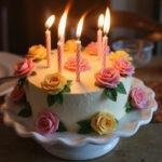Close-up of a beautiful flower birthday cake adorned with flowers and candles, perfect for a birthday celebration.