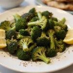 Final presentation of air fryer roasted broccoli garnished with lemon and sesame seeds, highlighting the delicious flavors.