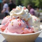 Delicious cotton candy ice cream served with whipped cream and sprinkles, perfect for summer treats.