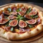 Delicious fig and prosciutto pizza served on a wooden board, showcasing its vibrant colors and textures.