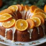 Final presentation of a delicious fruit cake mix creation, featuring a beautiful orange cake topped with mandarin oranges, ideal for celebrations.