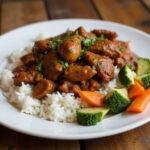 Final presentation of the delicious adobo chicken from Moe's, showcasing an attractive plate with rice and side vegetables.