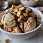 Delicious bowl of homemade moose tracks ice cream, showcasing chocolate and peanut butter swirls with peanuts on top.