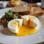 Deliciously served air fryer soft boiled eggs with a runny yolk, perfect for breakfast, displayed on a table with toast.