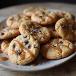 Delicious platter of salted caramel chocolate chip cookies drizzled with warm caramel and sea salt, perfect for dessert.