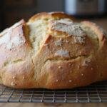 Freshly baked sourdough French bread loaf cooling, showcasing its golden crust and artisan texture.