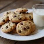 Deliciously baked toffee chocolate chip cookies displayed with a glass of milk on a wooden table.