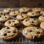 Golden brown butterscotch chocolate chip cookies cooling on a rack, highlighting their deliciousness and inviting appearance in a warm, homely kitchen.