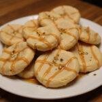 Elegant presentation of Chewy Ravenclaw Butterbeer Cream Cheese Cookies drizzled with butterscotch sauce and garnished, perfect for a magical treat.