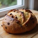 Freshly baked chocolate chip sourdough bread with a golden crust, showcasing the deliciousness of gourmet baking.