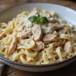 A delicious serving of creamy chicken caesar pasta salad in a rustic bowl, highlighting its flavor and freshness, perfect for any meal.