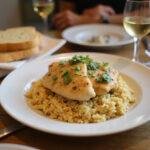 Final display of easy chicken scampi with garlic parmesan rice, alongside garlic bread and wine, perfect for a delicious meal.