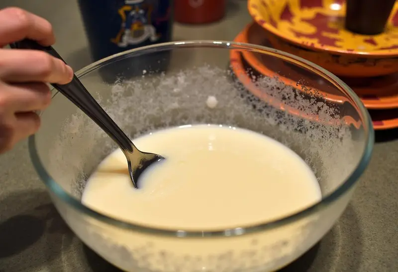Mixing french vanilla cake batter with milk and applesauce, creating a delightful cake mix for an Enchanted Harry Potter Birthday Cake.