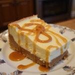 A delicious slice of Enchanted Hufflepuff Butterbeer Cheesecake Bars with Caramel Infusion, elegantly presented with caramel drizzle, perfect for dessert lovers.