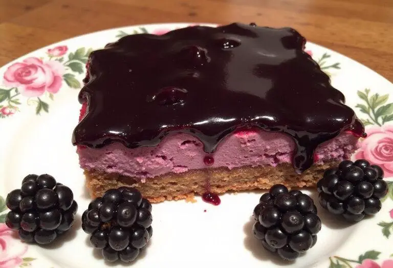 Completed Forbidden Forest Blackberry Cheesecake Bars with a Midnight Glaze, showcasing a luscious slice decorated with a midnight glaze and fresh berries on a decorative plate.