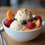 Delicious bowl of gluten-free ice cream topped with fresh fruits and nuts, perfect for a delightful gluten-free dessert experience.