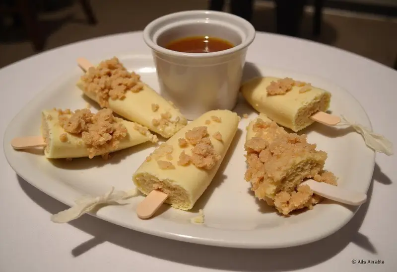 Final presentation of Hogsmeade’s Sweet Butterbeer Cheesecake Pops with a Vanilla Crunch on a decorative plate, emphasizing their delicious appearance and tempting toppings.