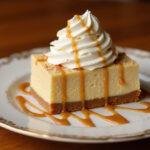 Stylish presentation of Hufflepuff Butterbeer Cheesecake Bars topped with whipped butterscotch on an elegant dessert plate.