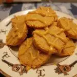 Delicious Hufflepuff Honeycomb Butterbeer Treats presented on a decorative plate, showcasing their golden-brown color and drizzled with butterscotch.