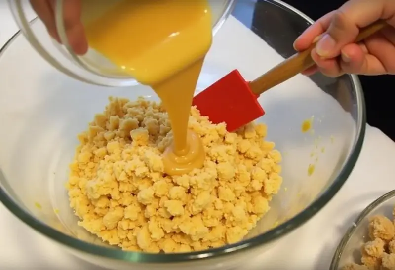 Crushed honeycomb in a bowl being combined with melted butter and butterscotch, creating a delicious mixture for Hufflepuff Honeycomb Butterbeer Treats.