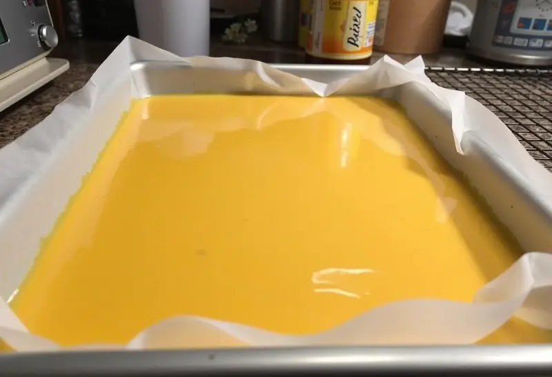 Honeycomb butterbeer mixture spread on a parchment-lined baking tray, awaiting refrigeration, essential for Hufflepuff Honeycomb Butterbeer Treats.