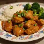 Serving the delicious Panda Express Orange Chicken Copycat Recipe, beautifully plated with rice and broccoli.