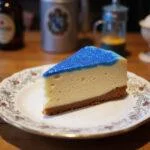 Final presentation of Ravenclaw House Butterbeer Cheesecake with shimmering blue topping, a magical and delicious dessert ready to be enjoyed.