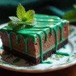 Delicious Slytherin Dark Chocolate Mint Cheesecake Bars with emerald drizzle served elegantly on a plate.