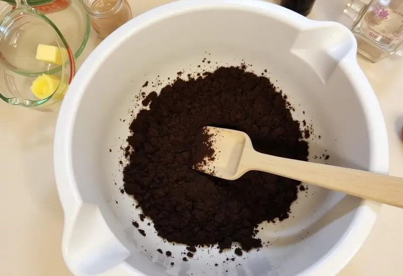 Crushed chocolate cookies mixed with melted butter for Slytherin Mint Cheesecake crust preparation.