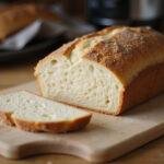 Final presentation of sourdough quick bread recipes, showcasing a freshly baked loaf on a cutting board, sliced and ready to serve.
