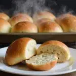 Freshly baked sourdough rolls including dinner, Hawaiian, and hot dog types, showcasing their golden color and delicious texture on a cooling rack.