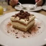 A stunning tiramisu-inspired dessert featuring rich layers and decorations, emphasizing the deliciousness of limoncello tiramisu, Oreo tiramisu, tiramisu ice cream, and tiramisu overnight oats.