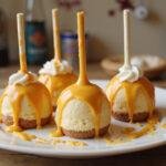 Delicious enchanted Hogwarts Butterbeer cheesecake pops with golden drizzle displayed elegantly.