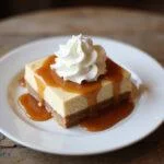 Enjoying the final result of Hufflepuff’s Sweet Butterbeer Cheesecake Bars, served with whipped cream and caramel, perfect for a delightful treat.
