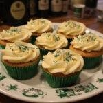 Deliciously decorated Slytherin’s Hidden Butterbeer Cupcakes on a platter, featuring rich frosting and themed sprinkles in a charming kitchen setting.