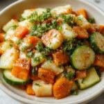 A vibrant Asian-inspired carrot cucumber salad served in a white bowl. The salad features julienned bright orange carrots, crisp green cucumber slices, and garnished with sesame seeds and fresh herbs. The colorful ingredients are arranged attractively against a rustic wooden background, highlighting the freshness and crunchiness of the vegetables.