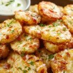 A plate of golden baked garlic parmesan potato wedges garnished with fresh parsley, crispy on the outside and cheesy on the inside.