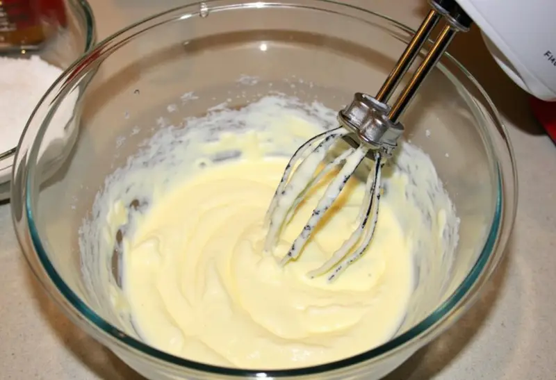 Preparing the filling for Harry Potter Rich Butterbeer Cheesecake with cream cheese and sugar.