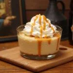 Delicious Harry Potter Single-Serve Butterbeer Cheesecake Cups ready to enjoy, featuring whipped cream and butterscotch.