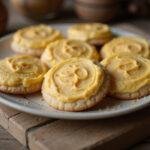Final presentation of Hogsmeade Butterbeer Cookies with Golden Buttercream Icing, artistically displayed on a rustic wooden table, perfect for enjoying a magical treat.