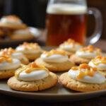 Final presentation of Hogsmeade Pub-Style Butterbeer Cookies with rich white buttercream, an inviting dessert spread on a rustic rustic table.