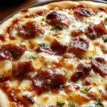 A delicious homemade prosciutto pizza topped with fresh basil and melted cheese on a wooden pizza peel.