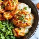 A vibrant plate of homemade butter chicken garnished with fresh cilantro, served with steaming basmati rice and naan bread.