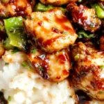 A colorful plate of teriyaki chicken stir-fry with vibrant vegetables and glossy sauce served on a white platter