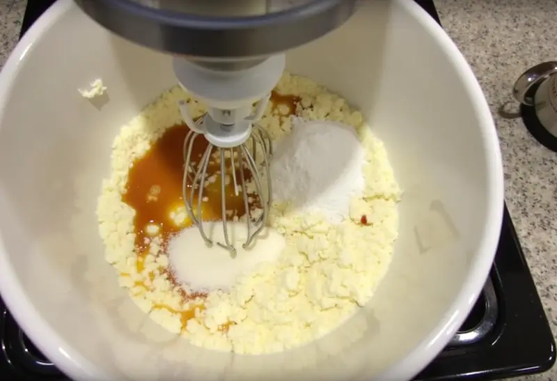 Ravenclaw Starry Night Butterbeer Cheesecake mixture in a bowl with cream cheese and sugar on a kitchen counter.