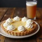 Displaying the finished Three Broomsticks Cream Soda Float Pie with Butterbeer Whipped Cream, emphasizing its creamy texture and inviting look on a rustic wooden table.
