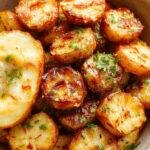 A vibrant plate of Zesty Mexican Potatoes garnished with fresh cilantro and lime wedges, showcasing crispy golden-brown potatoes with a spicy, colorful sauce.
