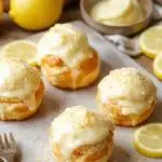 Delicious Zesty Spring Lemon Cream Puffs with golden-brown shells filled with vibrant lemon cream topped with fresh mint leaves.
