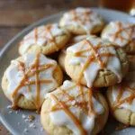 Final presentation of Hogsmeade Butterbeer Cookies with white buttercream icing and salted caramel, beautifully displayed on a rustic wooden table.